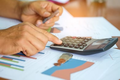 men-are-using-a-calculator-to-analyze-the-cost-of-a-credit-card--1536x1024